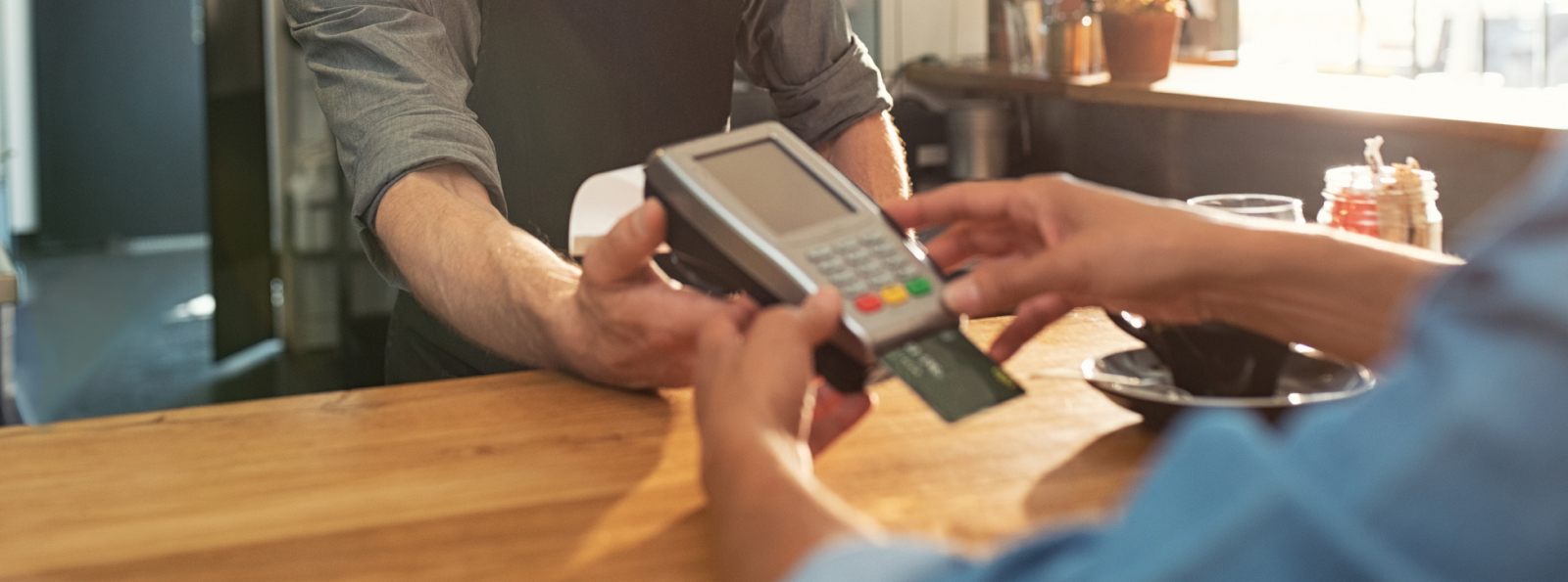 Merchant card machine taking payment from a customer at a business