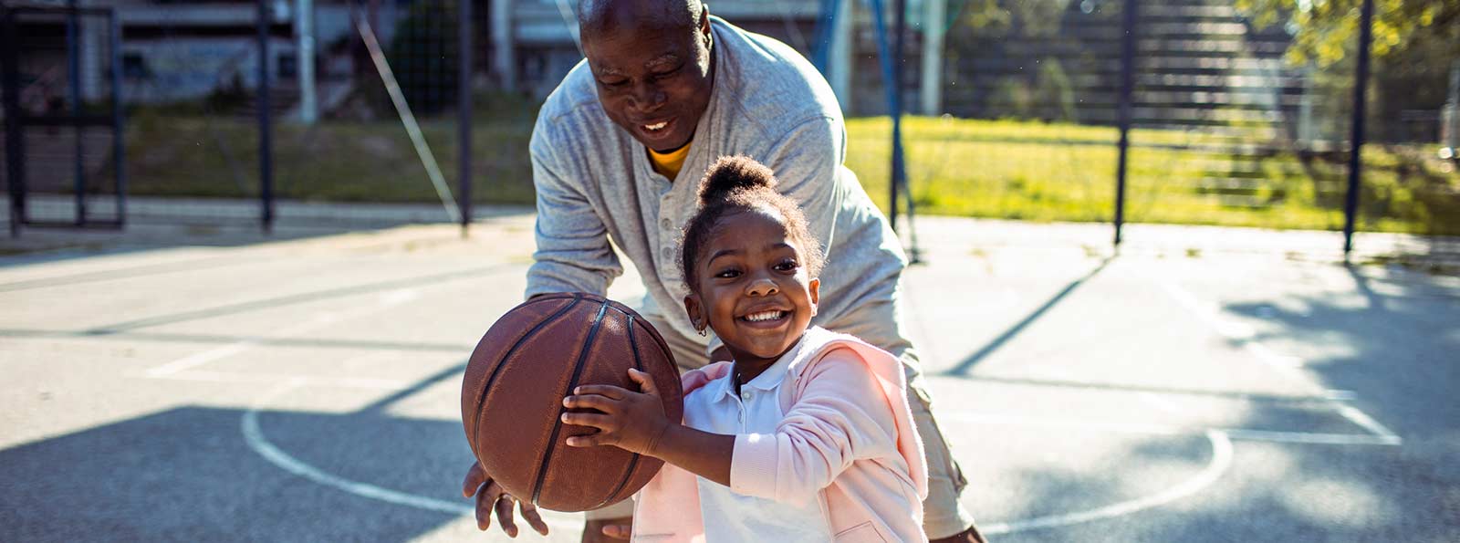 Grandpa playing basketball with his granddaughter